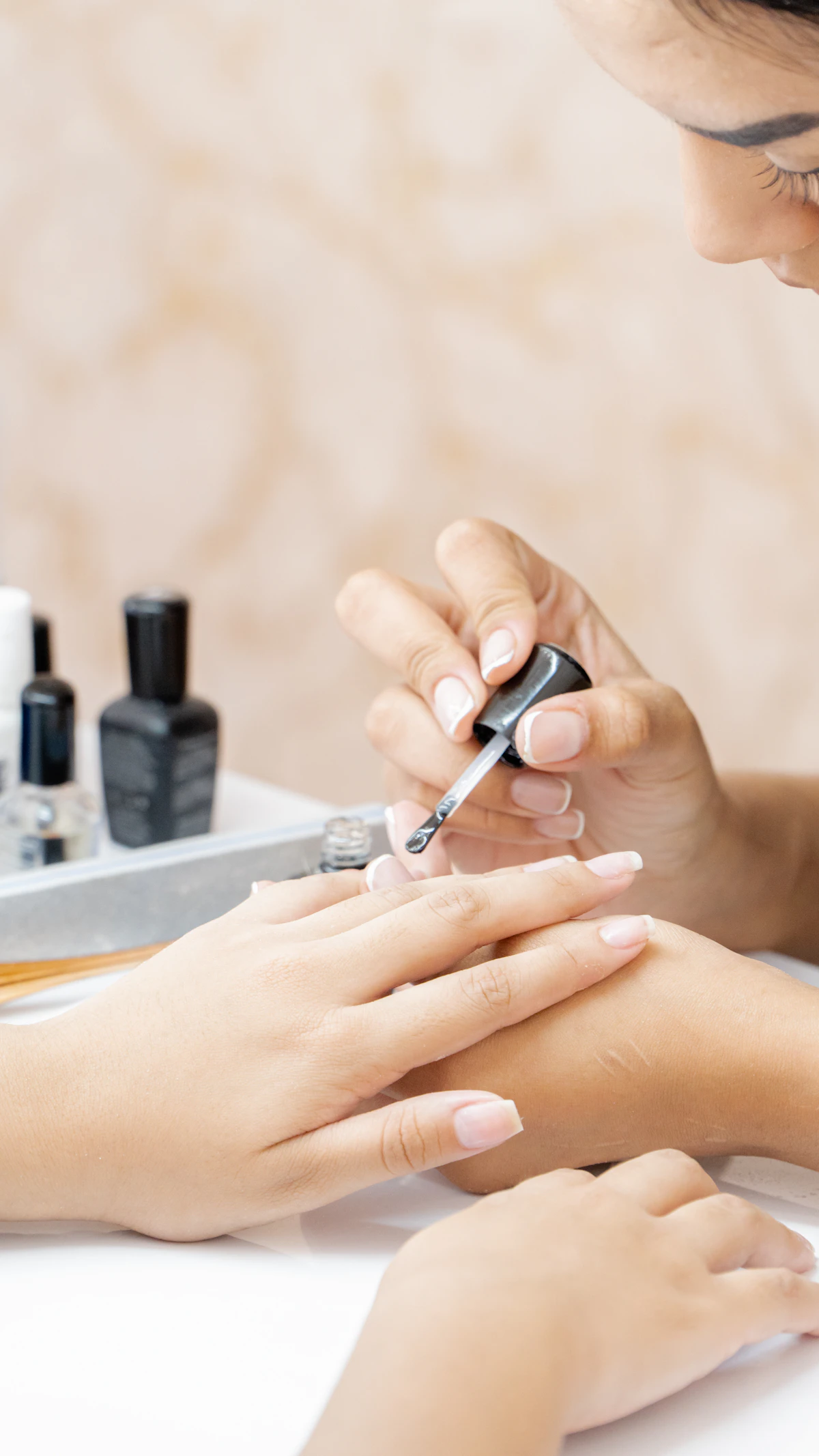 Nail technician carefully applying polish during a manicure